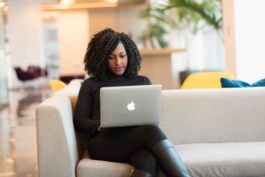 woman working at her computer sitting on a couch