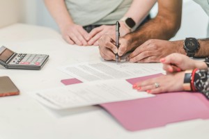 Someone's hands signing a financial document